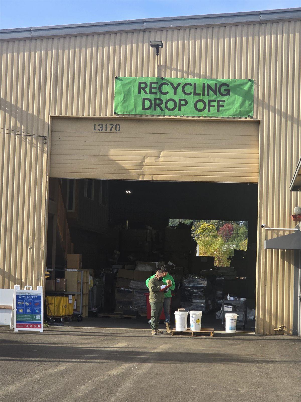 Tigard recycling drop-off entrance at 13170 SW Wall St, with the green Recycling Drop Off banner above the open loading-bay door.